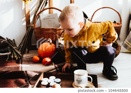 Cool trendy hipster boy 2 years old wears yellow jacket posing at the decorated photozone of autumn decor with beautiful bright autumn leaves. Cool trendy hipster boy 2 years old wears yellow jacket posing at the decorated photozone of autumn decor with beautiful bright autumn leaves. 104648800