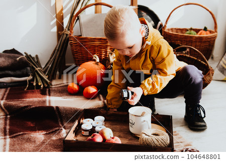 Cool trendy hipster boy 2 years old wears yellow jacket posing at the decorated photozone of autumn decor with beautiful bright autumn leaves. Cool trendy hipster boy 2 years old wears yellow jacket posing at the decorated photozone of autumn decor with beautiful bright autumn leaves. 104648801