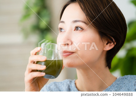 Young woman drinking green juice Food and drink image 104649888