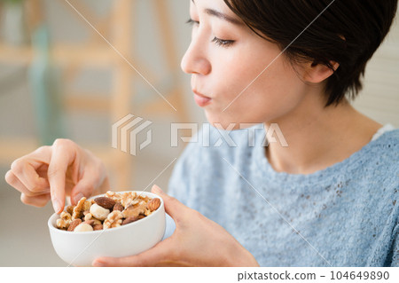 年輕女子吃混合堅果吃喝圖像 104649890