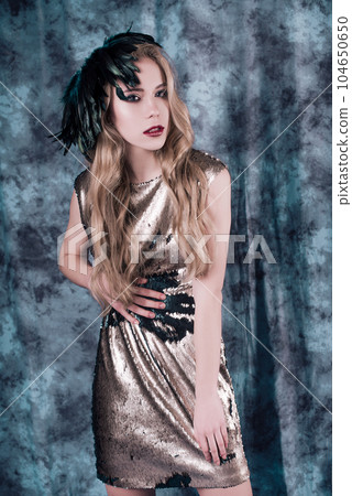 Attractive young woman posing in sequin dress. Studio image 104650650