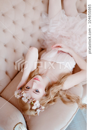 picture of young blonde woman wearing wreath of flowers, spring tender and romantic portrait, fashion retouched shot 104650865