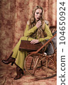 glamorous portrait of a beautiful young woman in a fur vest holding a bag 104650924