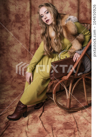 glamorous portrait of a beautiful young woman in a fur vest holding a bag glamorous portrait of a beautiful young woman in a fur vest holding a bag 104650926