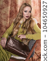 glamorous portrait of a beautiful young woman in a fur vest holding a bag 104650927