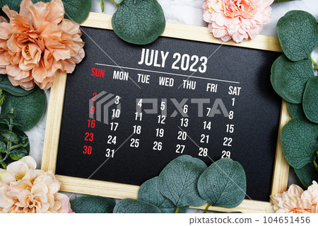 July 2023 monthly calendar with flower bouquet decoration on marble background 104651456