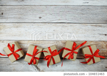 Gift boxes with red ribbon on wooden background 104651463
