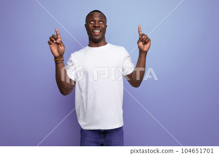 positive friendly young african man in white t-shirt on studio background with copy space positive friendly young african man in white t-shirt on studio background with copy space 104651701