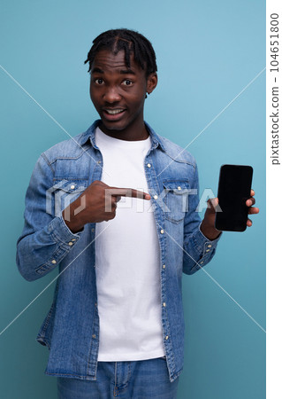 smiling african man with black dreadlocks using smartphone 104651800
