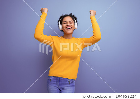 energetic cute young 25 year old hispanic lady listening to playlist in headphones 104652224