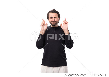 handsome brutal european macho man with black hair and beard with an earring in his ear crossed his 104652251