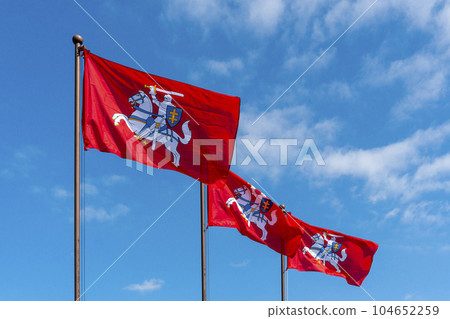 Historical Lithuanian flags waving in the wind against blue sky Historical Lithuanian flags waving in the wind against blue sky 104652259