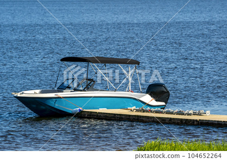 Motor boat or cutter moored to a pier 104652264