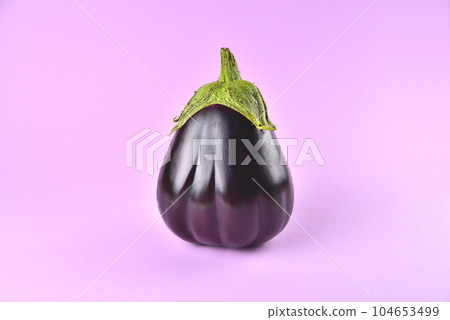 Eggplant on a purple background, fresh juicy vegetable on a colored background, selective focus, soft focus 104653499