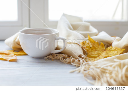 autumn leaves with a cup of tea or coffee next to a scarf on a wooden background with copy space autumn leaves with a cup of tea or coffee next to a scarf on a wooden background with copy space 104653837