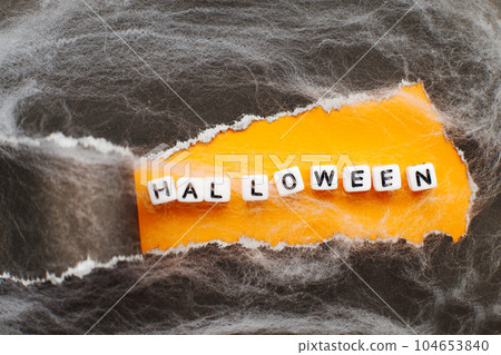 curl of torn black paper on orange background. halloween sale concept curl of torn black paper on orange background. halloween sale concept 104653840