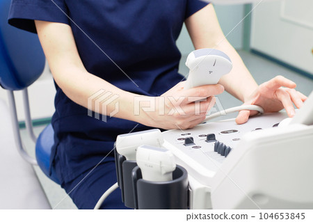 Female doctor sitting in office in a hospital doing ultrasound scanning diagnostic 104653845