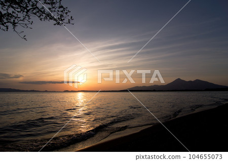 Evening view of Lake Inawashiro. The silhouette of Mt. Bandai, the sparkling sunset and lake surface, and the orange horizon against the blue sky are impressive and beautiful. Evening view of Lake Inawashiro. The silhouette of Mt. Bandai, the sparkling sunset and lake surface, and the orange horizon against the blue sky are impressive and beautiful. 104655073
