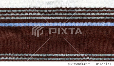 Handmade knitted fabric white brown and blue wool background texture Handmade knitted fabric white brown and blue wool background texture 104655135