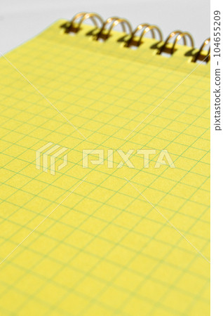 Wire spiral unlined yellow checkered lined paper isolated on white background Wire spiral unlined yellow checkered lined paper isolated on white background 104655209