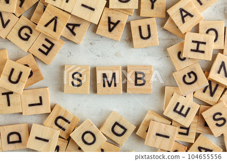 Top down view, pile of square wooden blocks with letters SMB (stands for Small to Medium Business ) on white board. Top down view, pile of square wooden blocks with letters SMB (stands for Small to Medium Business ) on white board. 104655556