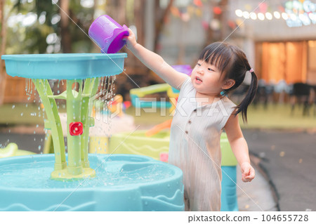 Asian girl playing water toys in playground, Cute child happy preschool little kid having funny while playing,  Learning and active of kids concept. 104655728