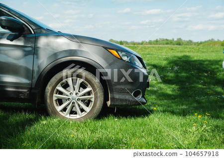a gray car parked on a green lawn a gray car parked on a green lawn 104657918