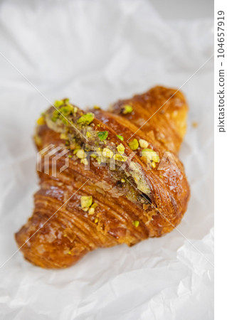 A mouth-watering croissant with a pistachio garnish in close-up A mouth-watering croissant with a pistachio garnish in close-up 104657919