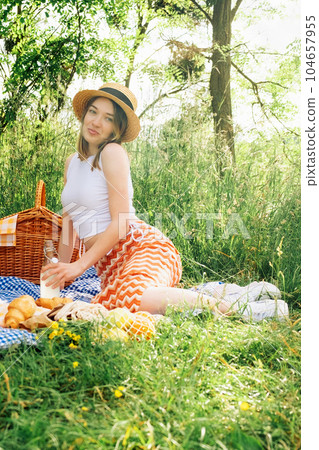 Outdoorsy young woman on blue blanket, having a picnic Outdoorsy young woman on blue blanket, having a picnic 104657955