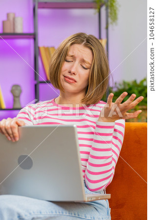 Pretty young woman use laptop surprised by bad news, fortune loss, fail, lottery results at home Pretty young woman use laptop surprised by bad news, fortune loss, fail, lottery results at home 104658127