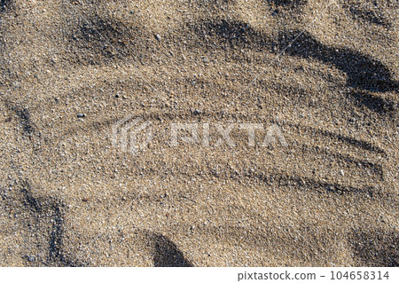 The texture of pure sand on the beach or in the desert. There is free space for the text. The texture of pure sand on the beach or in the desert. There is free space for the text. 104658314