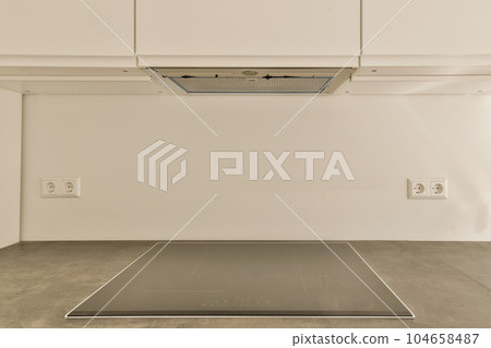 an air condition system in a room with white walls and gray flooring on the wall, there is a venttor above it 104658487