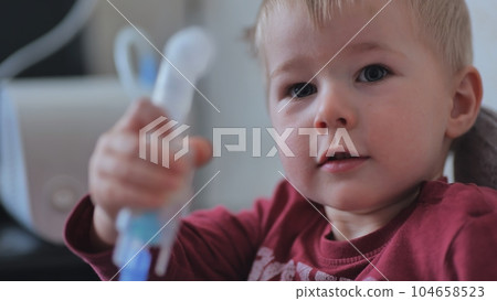 Funny boy breathing through an inhaler mask. Funny boy breathing through an inhaler mask. 104658523