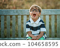 Little kid scared and amazed with big eyes and open mouth for surprise. Child of primary school surprised and happy to go to school. Kindergarten boy in glasses sitting outside 104658595