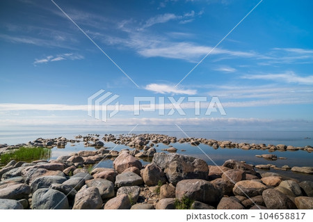 The rocky shore of the Baltic Sea. Beautiful sunny summer day, calm sea. Baltic Sea Estonia Kihnu Island. The rocky shore of the Baltic Sea. Beautiful sunny summer day, calm sea. Baltic Sea Estonia Kihnu Island. 104658817