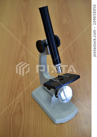 A school laboratory microscope. Laboratory with a microscope. A school laboratory microscope. Laboratory with a microscope. 104658950