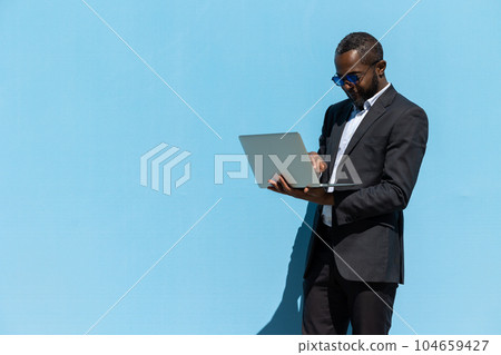 Mature businessman in elegant suit with a laptop looking busy 104659427