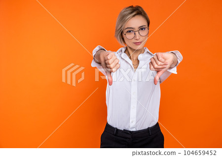 Dissatisfied woman wearing white official style shirt showing dislike gesture thumb down Dissatisfied woman wearing white official style shirt showing dislike gesture thumb down 104659452
