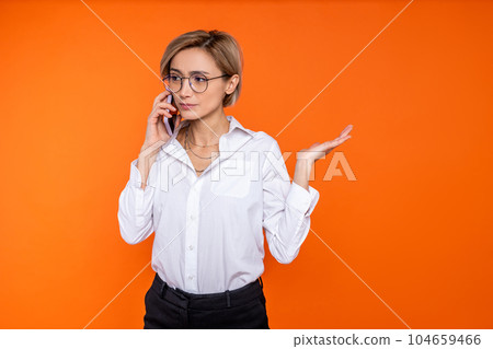 Confused uncertain woman wearing white official style shirt talking on cell phone 104659466
