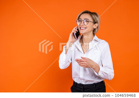 Satisfied woman wearing white official style shirt talking on smartphone Satisfied woman wearing white official style shirt talking on smartphone 104659468