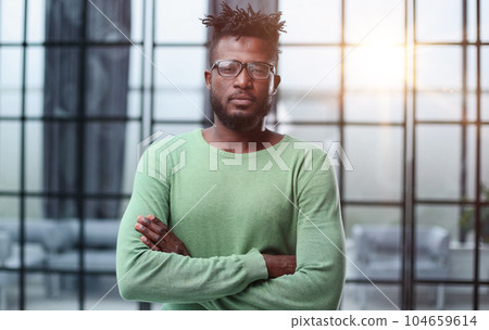 Portrait of a smiling CEO at workplace in a modern office in casual wear with glasses Portrait of a smiling CEO at workplace in a modern office in casual wear with glasses 104659614