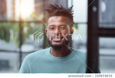 African American man in green sweater looking at camera 104659639