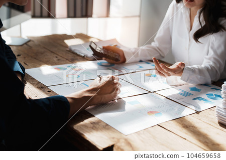 Accountant checking financial statement or counting by calculator income for tax form, Business woman sitting and working with colleague discussing the desk in office. Audit concept. Accountant checking financial statement or counting by calculator income for tax form, Business woman sitting and working with colleague discussing the desk in office. Audit concept. 104659658