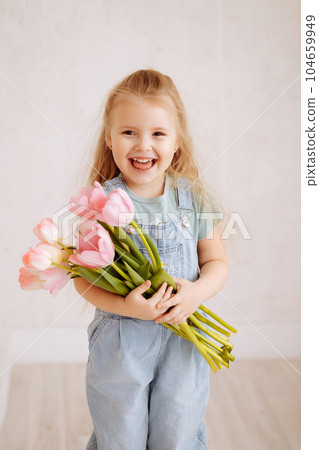 Portrait of a little blonde girl with a bouquet of spring flowers Portrait of a little blonde girl with a bouquet of spring flowers 104659949