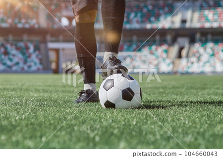 african american man holding a soccer ball in the stadium 104660043