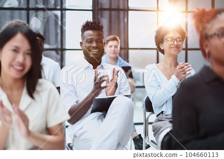 businesswoman applauding during seminar near interracial colleagues businesswoman applauding during seminar near interracial colleagues 104660113