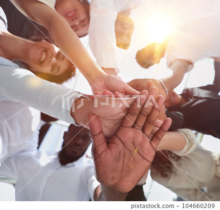 multinational business team looking down putting hands together 104660209