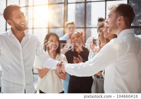 Businessmen reach out to each other to shake hands 104660418
