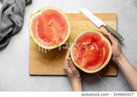 Fresh red juicy watermelon halves, watermelon slices on wooden chopping board. 104660427
