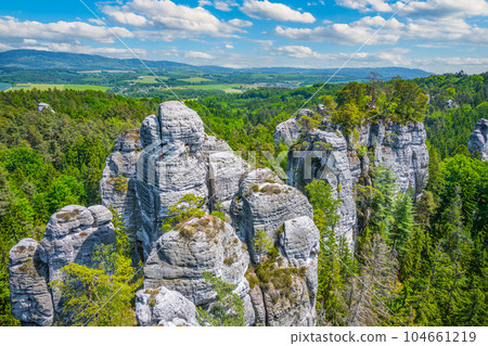Panoramic view of a sandstone rock city in Bohemian Paradise, Czech: Cesky raj. Rock climbers on top of a rocky tower. Czech Republic Panoramic view of a sandstone rock city in Bohemian Paradise, Czech: Cesky raj. Rock climbers on top of a rocky tower. Czech Republic 104661219